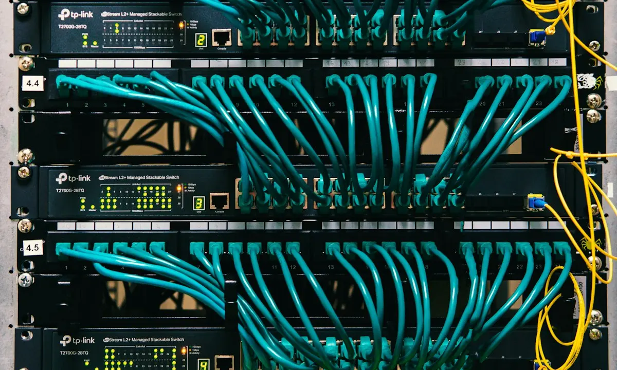 Stacked access switches and patch panels in a rack, where a two-minute switch reboot can trip a short Kubernetes toleration