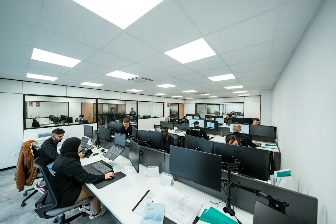 People working at desks in an open-plan office, the setting for Remote Desktop hosting